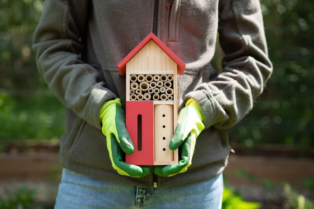 Houten insectenhotel in groenstrook van bedrijf